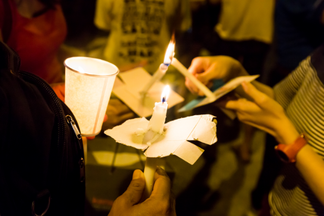 bigstock-People-Lighting-Candle-Vigil-I-167610578